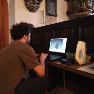 Operátor v notebooku prohlíží data získaná v průběhu skenování náhrobku