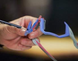 Barevné obroučky brýlí Oakley z 3D tisku Barevné obroučky brýlí Oakley držené v ruce