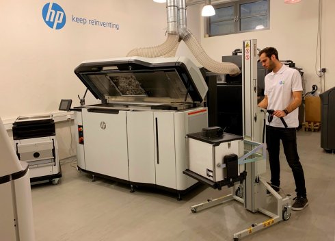 An operator works on an HP 5200 3D printer