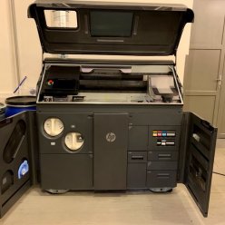 3D tiskárna HP 580 pro barevný tisk s otevřenými kryty stavební komory a přístupů pro doplňování spotřebního materiálů