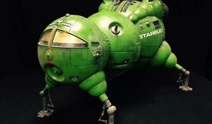 Kompletní model kosmické lodi pro filmové účely v sytě zelené barvě na černém pozadí