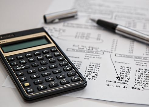 Kalkulačka a finanční tabulky Na vytištěných finančních výkazech je položená kalkulačka