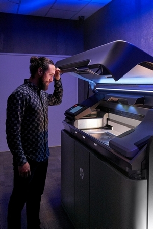 Muž se dívá do stavební komory 3D tiskárny